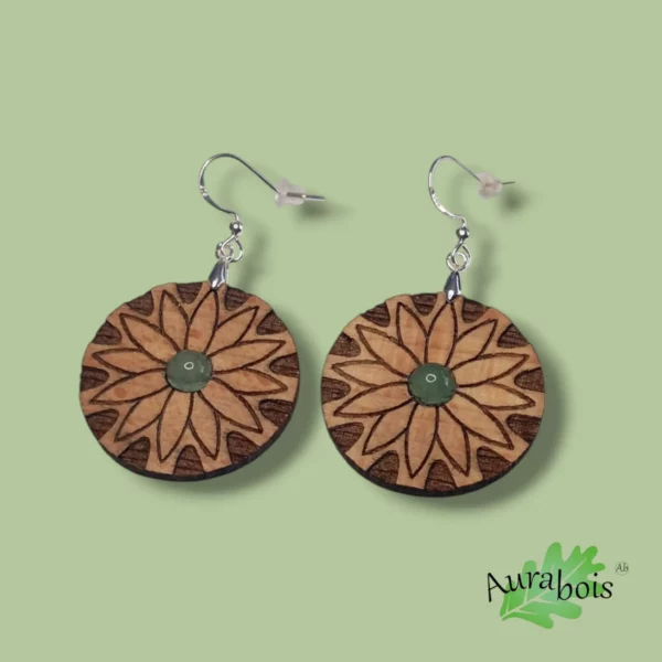 Boucles d'oreilles en bois de hêtre et pierre naturelle. La forme est ronde et la gravure représente une fleur de pâquerette. l'accroche de boucles est en laiton plaqué argent 925ème.