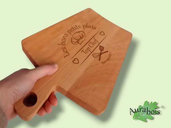 Planche à découper en bois de hêtre en forme de trapeize avec manche, gravée au laser et huilée à l'huile de lin. la gravure "les bons petits plats"