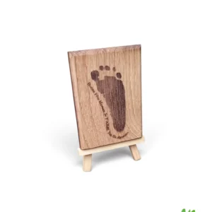 Décoration en bois de chêne avec empreinte réelle de bébé gravée au laser, présentée sur un chevalet en bois.
