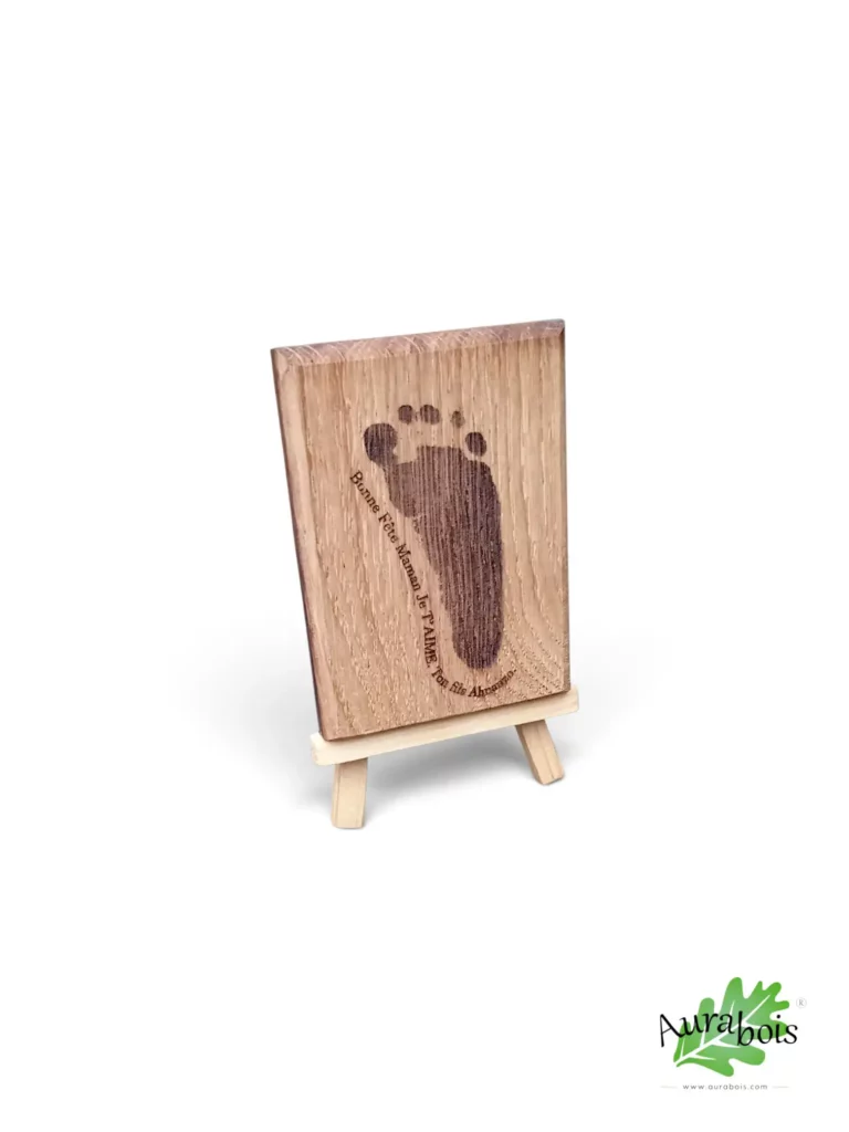 Décoration en bois de chêne avec empreinte réelle de bébé gravée au laser, présentée sur un chevalet en bois.